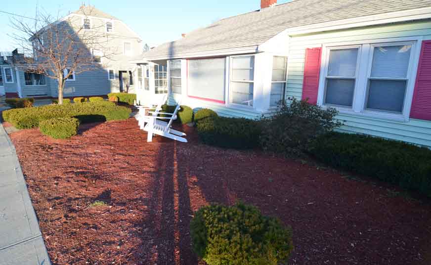 Dark red mulch covers the front of the property