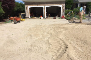 Compacted gravel is laid as driveway base